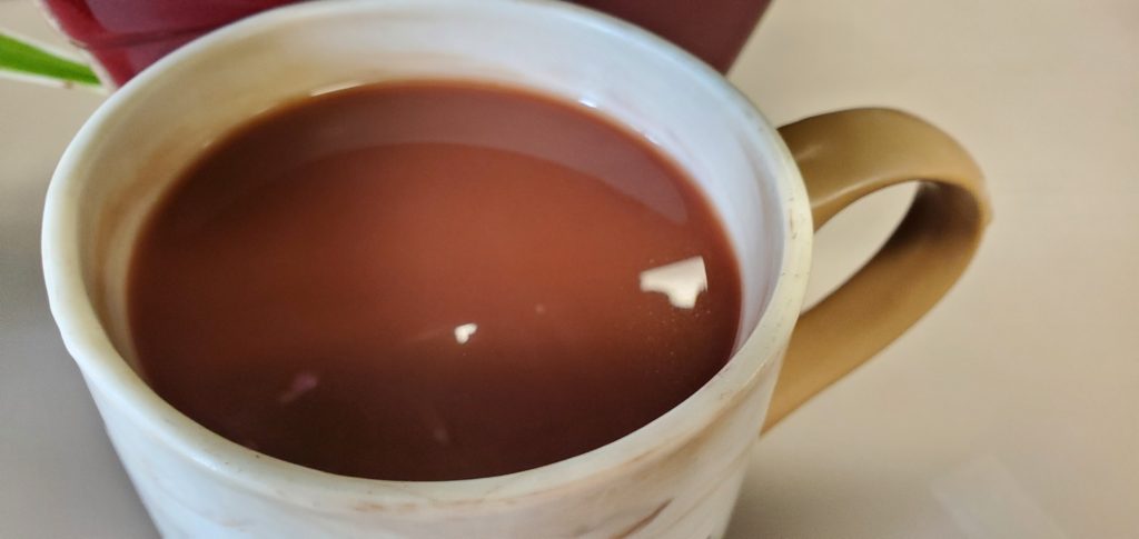 Cup of coffee with tiny heart reflection.